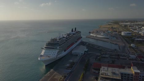 Aerial-view-of-the-big-cruise-ship-in-dock-next-to-a-smaller-ship-with-a-blue-skies-4K