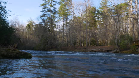 Panning-shot-of-a-calm-river-in-a-forest-at-Georgia-during-the-winter
