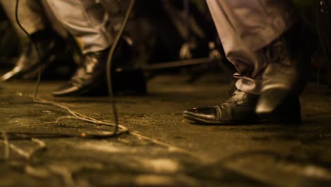 Low-angle-shot-of-a-band-members-feet-dancing-together-in-synchronisation-during-a-performance