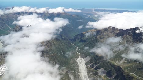 Aerial-shot-from-plane-scenic-flight-over-west-coast-Fox-Glacier-Aoraki-Mount-Cook,-National-Park-with-clouds,-snowcapped-rocky-mountains-and-ocean-in-background