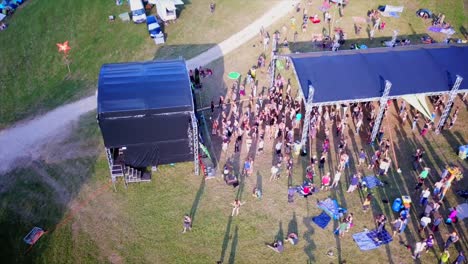 festival-with-dancing-people-in-front-of-a-stage-in-the-swiss-Jura-mountains-with-the-drone-from-the-air-filmed