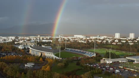 Colorful-rainbow-in-Reykjavik-at-national-football-stadium,-aerial