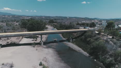 Aerial-shot-of-a-bridge-and-a-river-in-Badiraguato,-Sinaloa