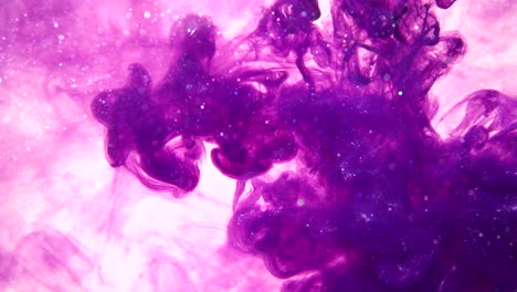 Purple-ink-drops-in-slow-motion-flowing-in-water-making-a-smokey-colorful-abstract-background