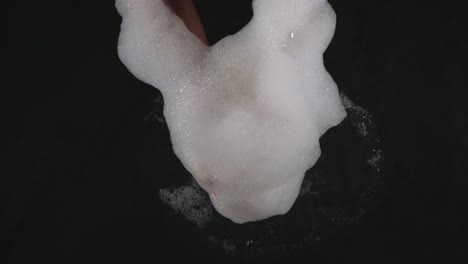 hands-in-foam,-black-surface-and-shaking-hands,-big-froth-of-soap