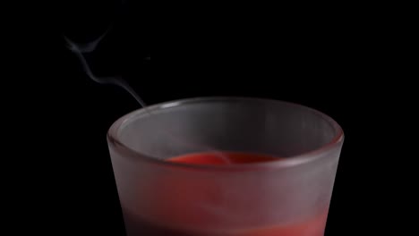 Smoke-rising-up-from-a-red-candle-which-got-blowed-out