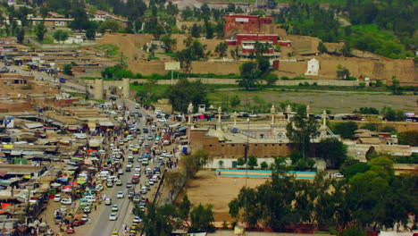 Peshawar,-Pakistan,-Aerial-view-of-busy-mountain-pass-connecting-the-Pak-Afghan-border-through-white-range-with-valley-of-Peshawar,-With-road-a-old-fortress-view