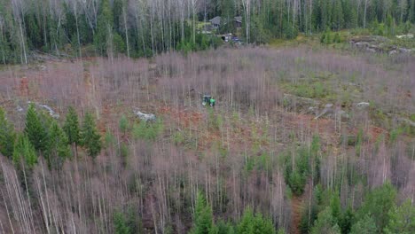 drone-footage-of-green-tractor-cutting-down-trees