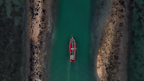 Aerial-flight-up-follow-above-fisherman-boat-goes-from-dock-among-coral-reefs