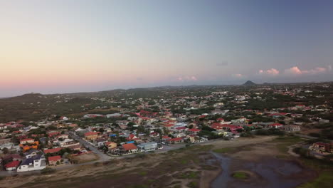 Neighborhoods-in-Aruba-with-Hooiberg-and-the-Caribbean-Sea-in-the-background-during-sunset
