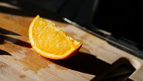 Eine-Bunte-Orangenfruchtscheibe-Auf-Einem-Schneidebrett-Im-Sonnenlicht-Für-Einen-Gesunden-Snack