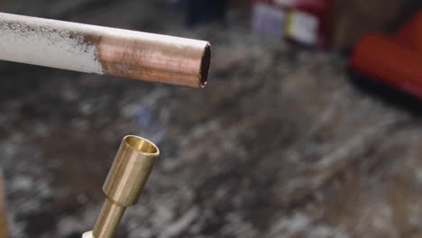 a-reclaimed-copper-pipe-is-being-heated-with-a-blow-torch