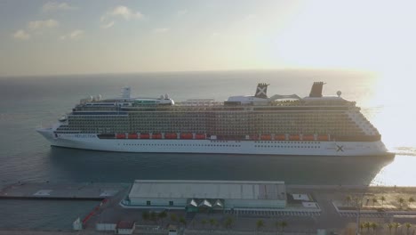 Aerial-close-up-view-of-a-big-cruise-ship-leaving-the-dock-on-a-sunny-day-4K
