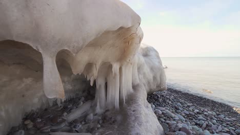 ice-cavern-on-the-edge-of-pebble-beach-slowly-melting-in-4k