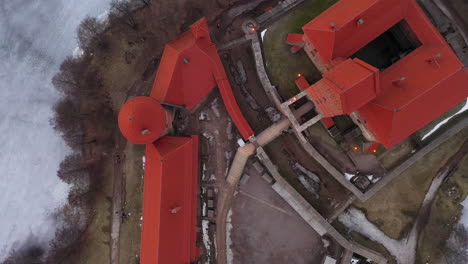Luftbild:-Topaufnahme-Der-Burg-Trakai-Mit-Zugefrorenem-See-Und-Bäumen-Auf-Dem-Boden