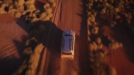 Aerial-Drone-top-high-speed-follow-4WD-Truck-down-gravel-road-in-Australian-Desert