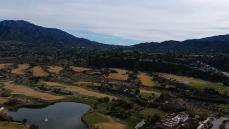 Drone-panning-left-then-down-going-from-shot-of-the-mountains-to-an-amazing-view-of-the-golf-course-fountain-and-lake
