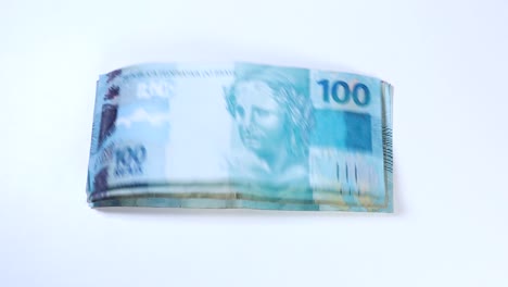 A-stack-of-Brazilian-Reais-banknotes-are-being-blown-away-by-the-wind-until-none-are-left