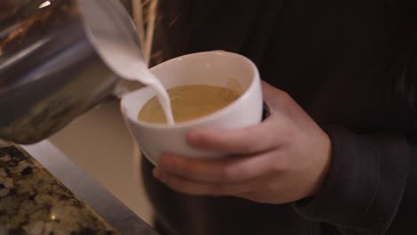 Barista-Gießt-Latte-Art-In-Becher