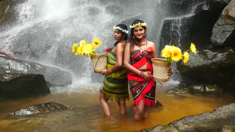 Traditionell-Gekleidete-Kambodschanische-Frauen-Posieren-Mit-Blumen-Vor-Dem-Wasserfall