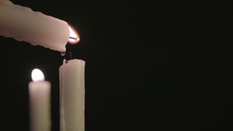 Eine-Weiße-Kerze-Beleuchtet-Eine-Weiße-Kerze-Mit-Einer-Brennenden-Kerze-Im-Hintergrund