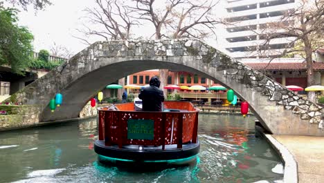 Riverboats-patrol-the-Riverwalk-routes-to-ferry-visitors-around-the-area's-restaurants,-sights,-and-sounds
