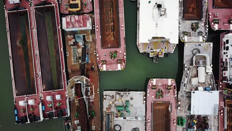Aerial-view-of-abandoned-cargo,-transporting-and-tanker-ships-at-a-port,-dock