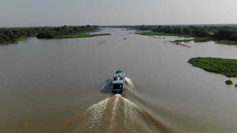 Drohnenaufnahme-Aus-Der-Luft-Nach-Einem-Langsam-Fahrenden-Boot,-Das-Den-Sangker-Fluss-In-Kambodscha-Hinunterfährt