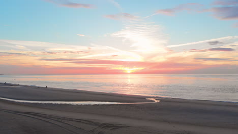 Eine-Ruhige-Ebbe-Am-Strand-In-Der-Nähe-Des-Sturmflutwehrs-Im-Südwesten-Der-Niederlande,-Während-Des-Sonnenuntergangs