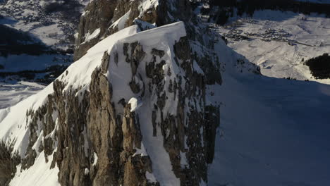 Aerial-view-flying-along-a-rocky-and-snowy-mountain-ridge-in-the-French-Alps-near-La-Clusaz-in-winter