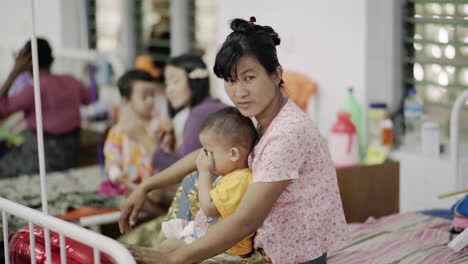 Lächelnde-Birmanische-Mutter-Mit-Ihrem-Kind,-Das-In-Die-Kamera-Schaut-Und-Daumen-Nach-Oben-Zeigt