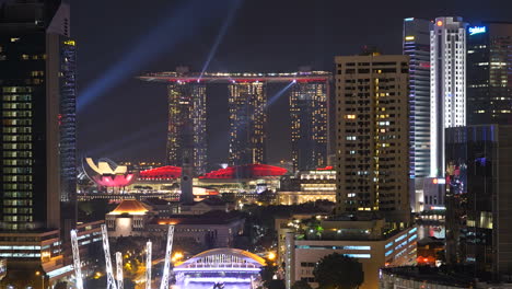 Zeitraffer-Nach-Oben-Kippen,-Singapur-Bei-Nacht-Mit-Lasershow-Am-Strand-Der-Marina-Bay