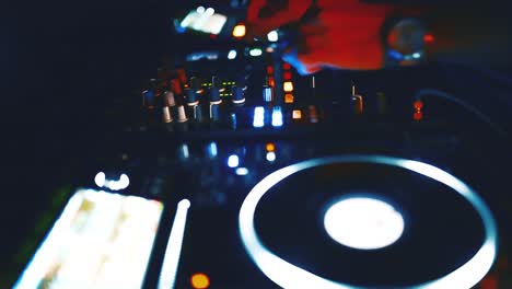 Close-up-view-of-DJ's-hand-controls-on-the-deck-at-night
