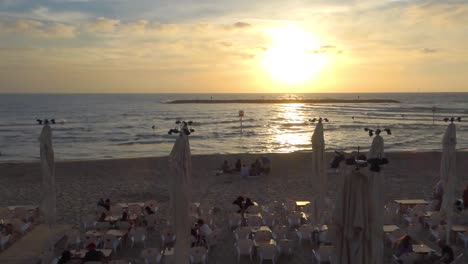People-sitting-in-a-bar-on-the-beach-in-Tel-Aviv,-Israel