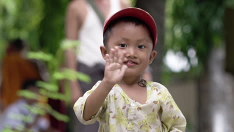 Glückliches-Birmanisches-Kind-Mit-Lippenspalte,-Das-In-Die-Kamera-Winkt