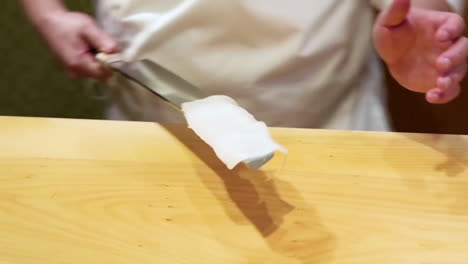 A-chef-by-knife-plays-with-squid-place-it-on-board-for-cutting