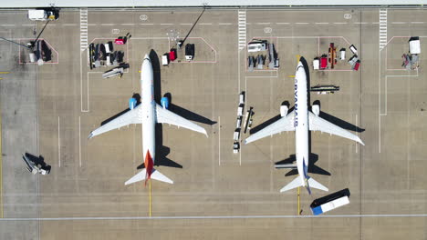 Eine-Vogelperspektive-Von-Zwei-Flugzeugen,-Während-Sich-Das-Bodenpersonal-Darauf-Vorbereitet,-Die-Passagiere-Von-Bord-Zu-Bringen