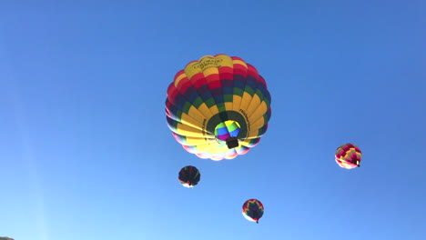 Rotating-shot-of-4-hot-air-balloons-directly-overhead