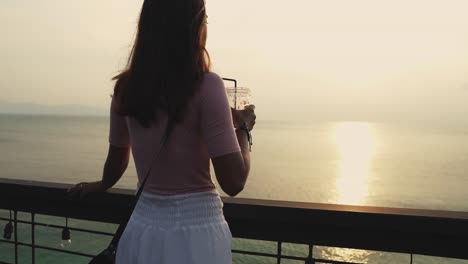 Girl-on-the-rooftop-cafe-drinking-shake-and-enjoying-sunset-and-sea-view