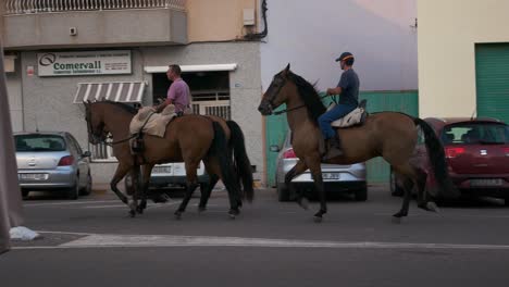 Men-riding-horses-in-a-small-spanish-village,-Vall-d'Alba