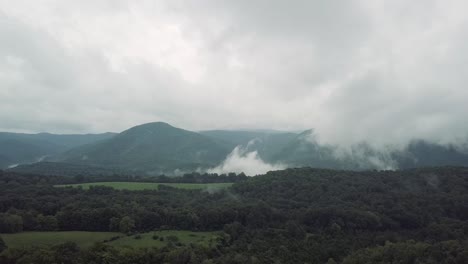 Drone-flying-up-over-forest-and-trees-in-the-Smoky-Mountains,-USA-into-the-cloudy-sky-for-an-incredible,-gorgeous-scene