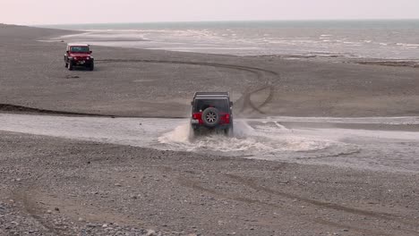 Zwei-Jeep-Wrangler-überqueren-Einen-Bach-Am-Strand-Von-Cooks-Inlet-Auf-Der-Halbinsel-Kenai-In-Alaska