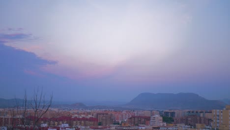 The-camera-turns-until-we-see-beautiful-landscape-of-a-mountainous-city,-with-a-cloudy-sky-of-purple-and-red
