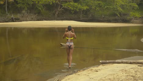 Bikini-model-with-sexy-buttocks-walking-into-the-shallow-river