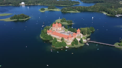 AERIAL:-Flying-Over-Trakai-Island-Castle-with-a-Lot-of-Visible-Boats-Sailing-Around-on-the-Surface-of-Lake