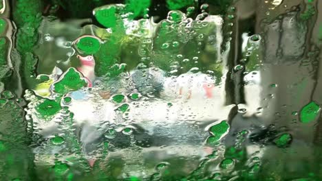 Different-stages-driving-through-a-tunnel-car-wash,-Multicolored-foam-and-water-and-bubbles,-rinse-and-wax