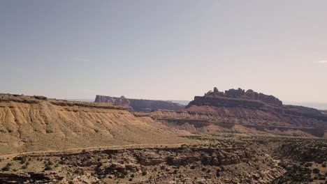Increíbles-Y-Hermosas-Imágenes-De-Drones-Que-Vuelan-Hacia-La-Roca-De-La-Mesa-Sobre-El-Valle-Del-Desierto,-Los-Arbustos-Y-El-Paisaje-En-El-Cañón-Del-Dragón-Negro-En-El-Río-Verde,-Utah,-Estados-Unidos