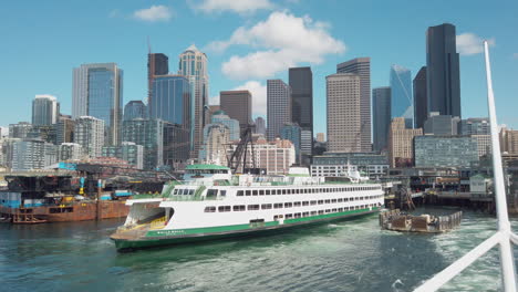 View-of-Pier-52-and-Downtown-Seattle-from-water-aboard-Washington-State-Ferry-departing-Colman-Dock-as-another-ferry-arrives