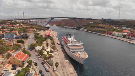 A-Harbour-with-two-cruise-ships-docked-in-port-with-a-bridge-in-the-background-in-Willemstad,-Curacao