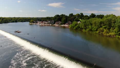 Descending-aerial-drone-dolly-shot-toward-Fairmount-Park-above-Schuylkill-River-waterfall-on-beautiful-summer-day